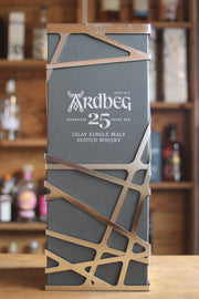 A bottle of Ardbeg 25-year-old whisky with a decorative label against a blurred bar background.